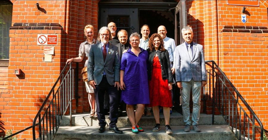 A group of people standing in a front of Collegium Maius
