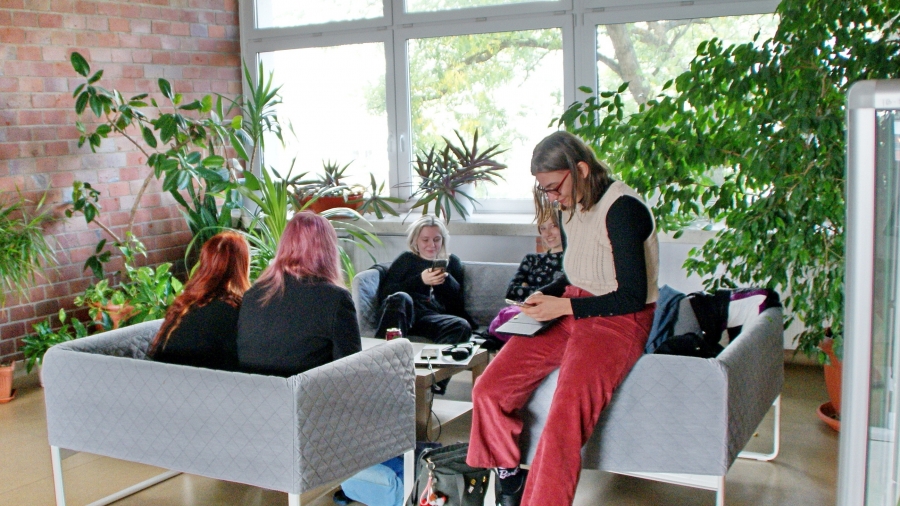 Grupa studentów siedząca na kanapie na WNBiW, w tle rośliny