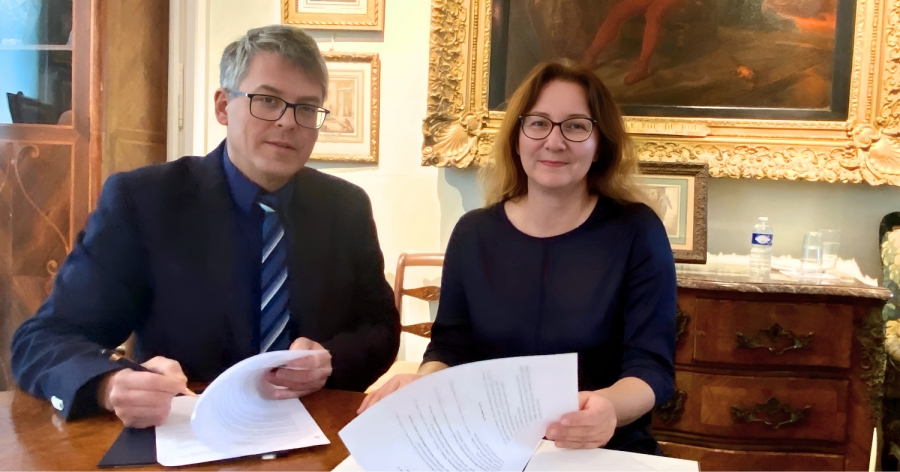Mężczyzna i kobieta siedzą przy biurku i przeglądają dokument.