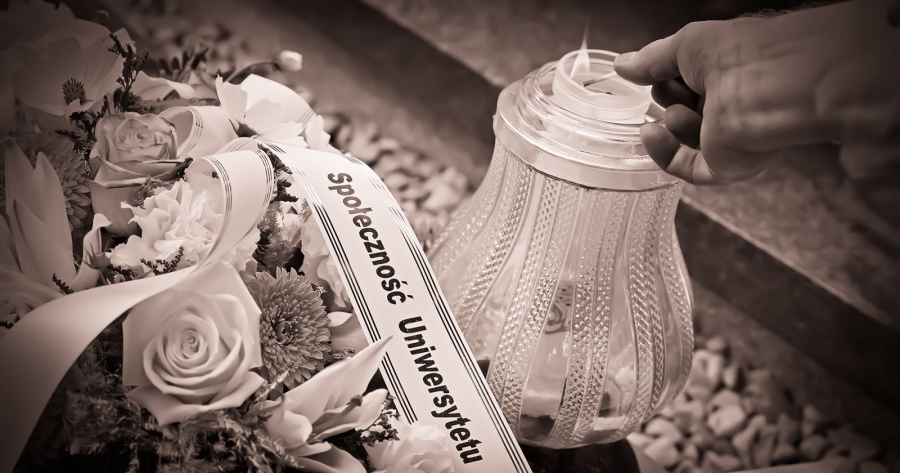 Wiązanka leżąca na pomniku z szarfą z napisem 