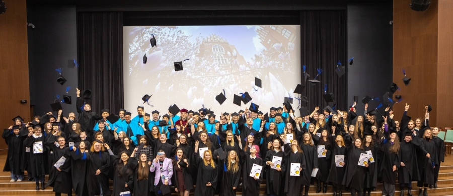 W Auli UMK absolwentki i absolwenci Wydziału Humanistycznego podrzucają w górę birety. 