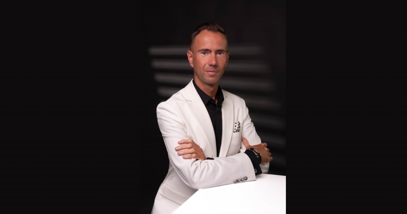 Mężczyzna w białym garniturze na czarnym tle