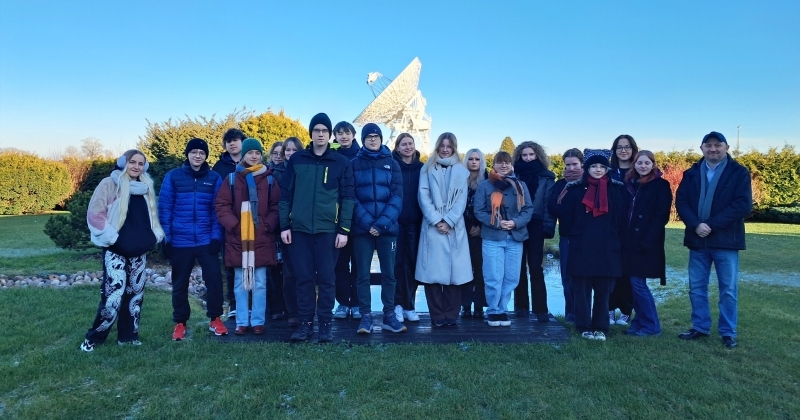 Uczniowie i prowadzący warsztaty stojący w holu instytutu astronomii w Piwnicach