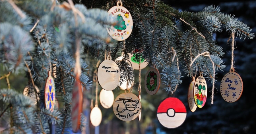 Christmas tree branches with wooden, hand-decorated ornaments