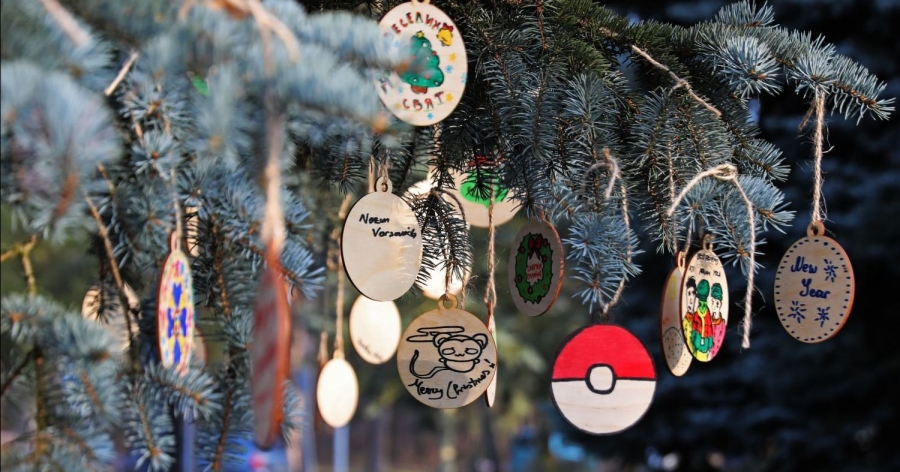 Gałęzie choinki, a na nich drewniane, ręcznie zdobione bombki