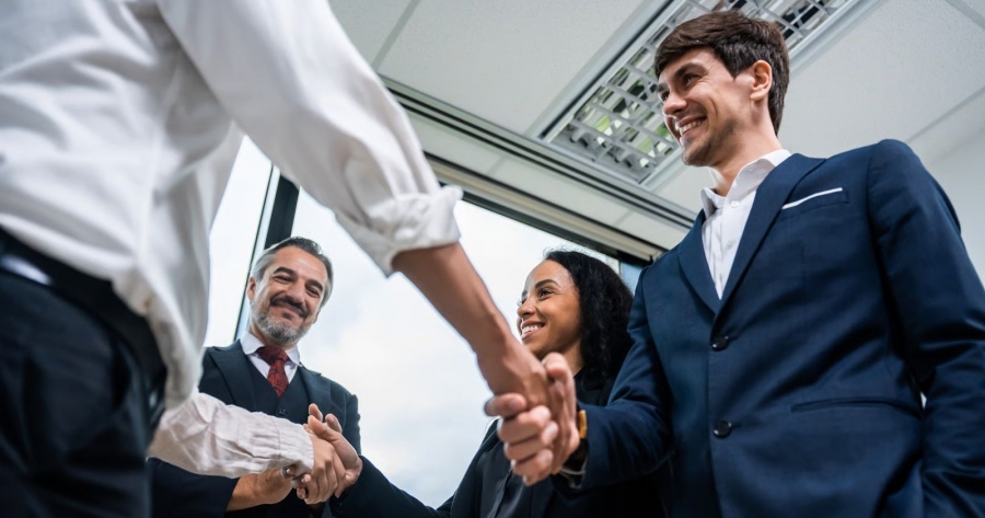 Dwoje młodych ludzi podaje ręce osobom poza kadrem