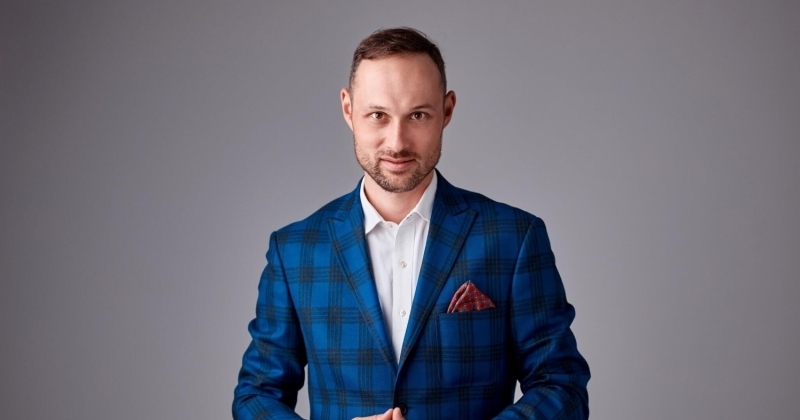 Mężczyzna w garniturze z rękami w piramidkę