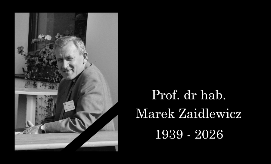 Prof. dr hab. Marka Zaidlewicz, uśmiechnięty siedzi za stołem, spogląda w stronę obiektywu. Konferencja naukowa na Słowacji.