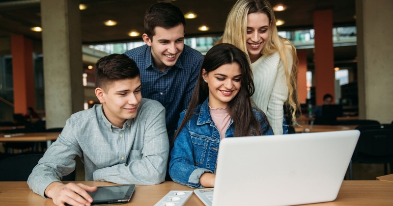 studenci siedzący przy laptopie 