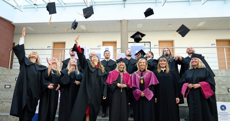 Ludzie w togach rzucający biretami.