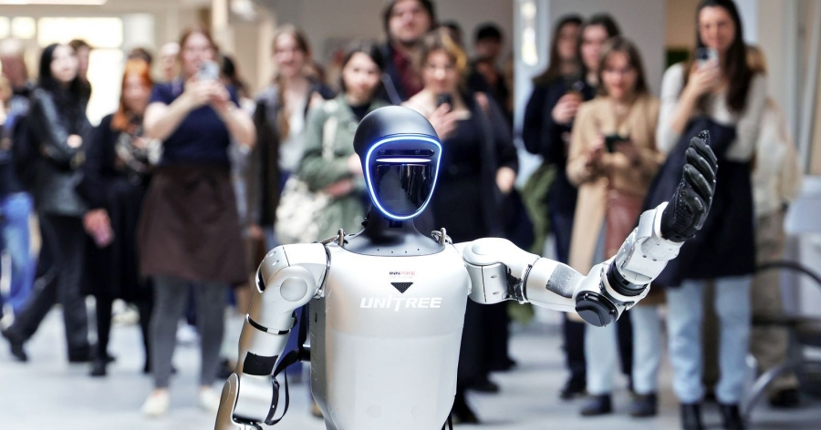 Humanoidalny robot unosi rękę w geście pozdrowienia