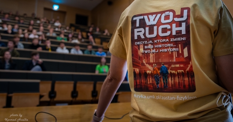 Zdjęcie Audytorium Aleksandra Jabłońskiego - widać prelegentkę z koszulką reklamującą studia fizyki