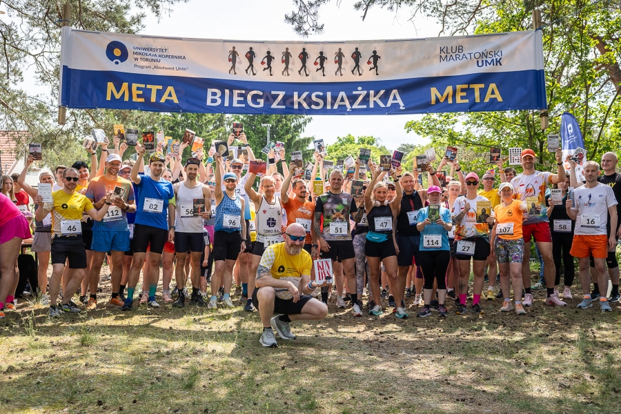 na zdjęciu grupa biegaczy pod banerem biegu