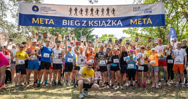 na zdjęciu grupa biegaczy pod banerem biegu
