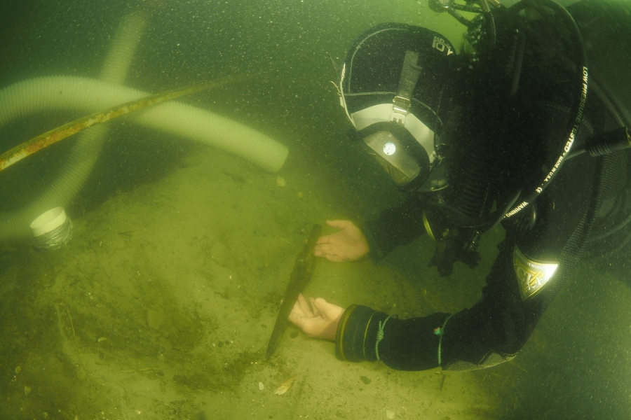 Archeolog eksplorujący grot włóczni [fot. Marcin Trzciński]